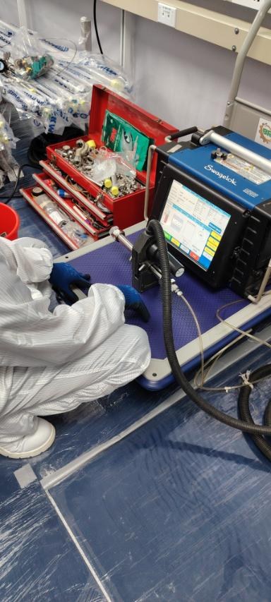 Technician working at a Swagelok orbital welder control unit inside the cleanroom